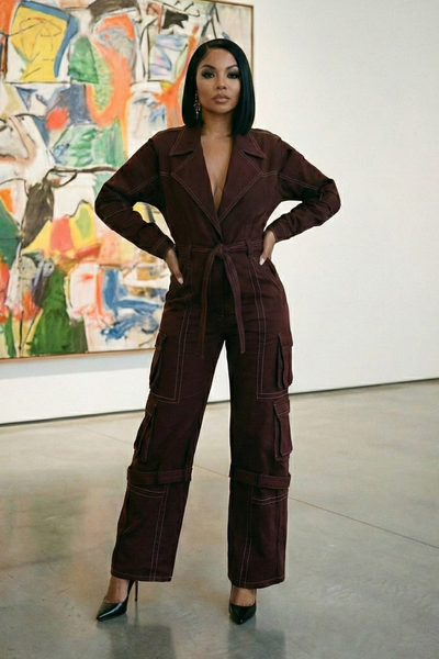 Person wearing a brown jumpsuit in an art gallery setting